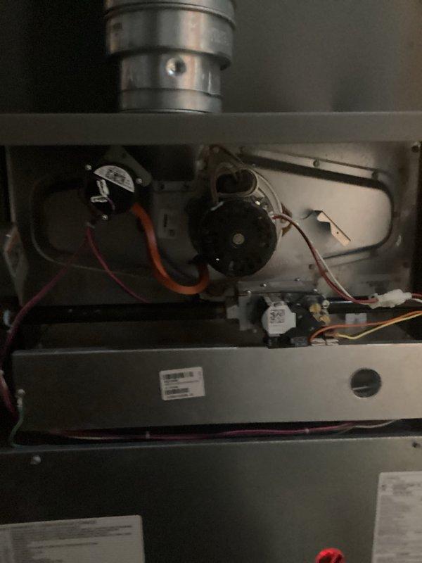 # HVAC Maintenance - AHM Service Report

Performed comprehensive air handler maintenance on residential HVAC system. Accessed furnace cabinet and inspected internal components including blower motor assembly, electrical connections, and wiring harnesses. All wire connections were verified secure with proper routing of orange, pink, red, and white conductor bundles throughout the unit.

Conducted thorough inspection of blower motor housing and associated mechanical components within the gray metal furnace cabinet. Examined capacitor, relay switches, and control components for proper operation. Verified all manufacturer specifications on unit labels and confirmed system integrity.

Replaced air filters and humidifier pads as scheduled for recurring maintenance service. Inspected ductwork connections at top of unit and confirmed secure attachment. All access panels were properly reinstalled following completion of maintenance procedures. System left in operational condition ready for cont