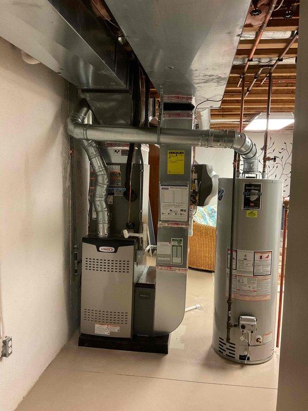 # HVAC Complete System Installation

Successfully completed installation of a complete HVAC system consisting of a 90,000 BTU furnace and 3-ton air conditioning unit with rear discharge configuration. The Lennox furnace was professionally installed in the basement mechanical room with proper clearances and code-compliant specifications. Integrated a humidifier into the system for enhanced indoor air quality control. Reconnected all existing utilities and established proper condensate drainage using white PVC piping. 

The installation included silver flexible ductwork connections from the furnace with metallic elbow transitions for optimal airflow distribution. All mechanical, electrical, and HVAC permits were obtained prior to installation to ensure full code compliance. System commissioning verified proper operation of both heating and cooling components. The equipment was installed with appropriate safety clearances from the existing water heater and other mechanical equipment in th