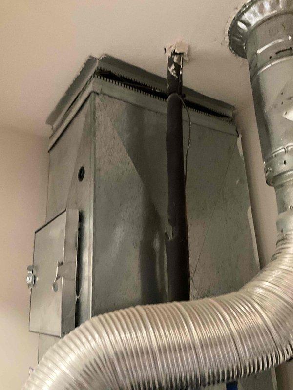 # HVAC System Replacement Estimate

Conducted on-site evaluation of 21-year-old furnace and air conditioning system requiring complete replacement due to age and end of service life. Documented existing ductwork configuration, plenum connections, and flexible duct routing to assess compatibility with new equipment installation. Photographed current HVAC components including ceiling-mounted supply plenum with access panel, flexible aluminum ductwork connections, rigid metal duct transitions, and associated PVC condensate drainage piping to establish baseline conditions and plan replacement specifications.