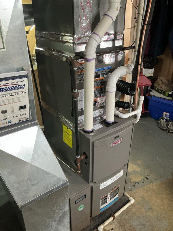 Completed installation of 2-ton air conditioning system with matching evaporator coil on left side return configuration. Installed outdoor condenser unit on concrete pad in side yard with refrigerant lines and electrical disconnect, connected indoor evaporator coil to existing Lennox furnace, and performed electrical and mechanical reconnection to ensure proper system operation.