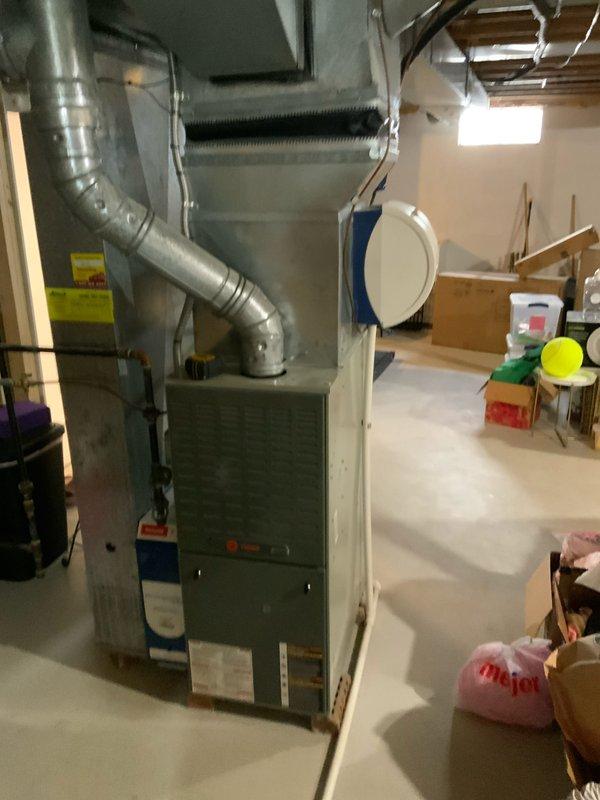 # HVAC Full System Estimate Report

Responded to service call for 16-year-old residential furnace system experiencing loud humming noise originating from the inducer motor. Performed comprehensive system evaluation to provide comparison between component replacement and complete system replacement options. 

Conducted thorough inspection of existing HVAC equipment located in unfinished basement utility area. Assessed furnace unit manufactured in 2005, documenting overall system condition, ductwork configuration, and installation environment. Evaluated inducer motor operation and identified source of abnormal humming noise consistent with bearing failure or motor degradation typical of units in this age range.

Documented existing system configuration including furnace unit, metallic ductwork with multiple elbows, and current venting arrangement. Photographed equipment layout, surrounding utility space, and mechanical connections to support estimate preparation. Noted exposed wooden fra