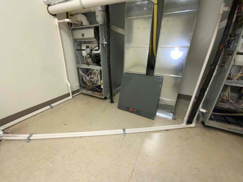 Completed site assessment of commercial building with residential units to provide updated quote for furnace replacement. Inspected existing HVAC equipment on second floor, including 7 furnaces, 7 air conditioning units, and multiple hot water tanks. Documented current furnace installations, noting dual furnace configurations with gas line connections, electrical panels, and ductwork systems. Photographed mechanical room equipment to support quote preparation for 2-unit furnace replacement project.