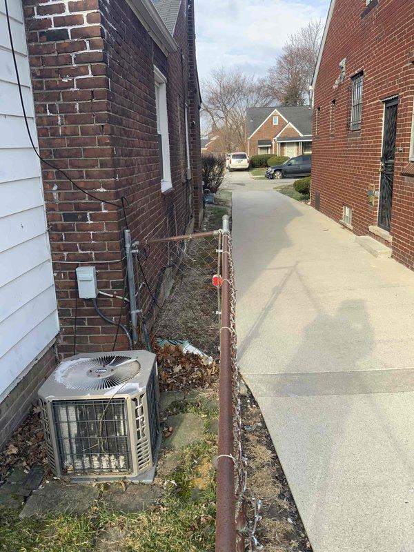 Completed full system estimate for residential HVAC replacement. Evaluated existing 16-year-old furnace and air conditioning system with customer requesting immediate replacement. Documented exterior condensing unit showing significant age-related wear and deterioration, photographed equipment location in side yard service area between buildings, and assessed installation requirements including electrical disconnect and clearance specifications for new system installation.