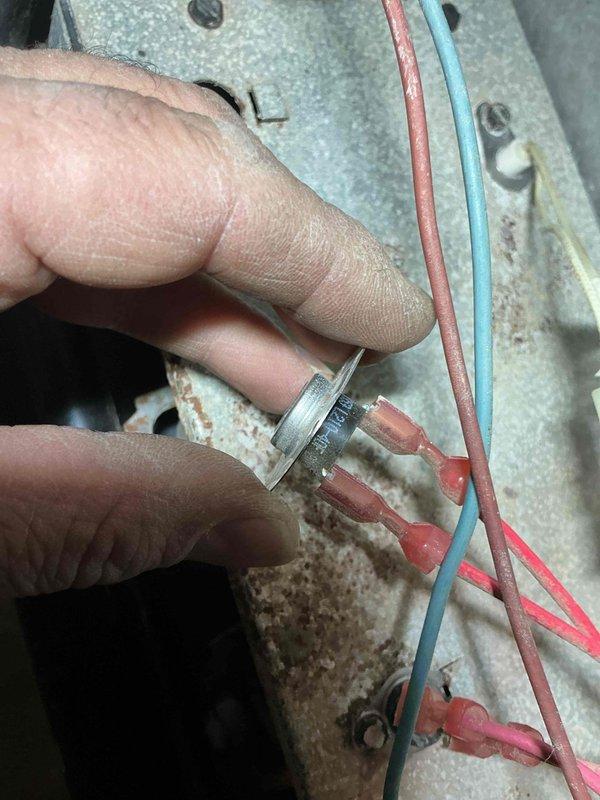 Replaced defective thermal limit switch on HVAC unit. Disconnected existing wiring, removed failed safety device from mounting panel, installed new thermal fuse with proper wire terminations using crimp connectors, and secured component to galvanized panel. Verified all electrical connections were tight and system restored to safe operating condition.