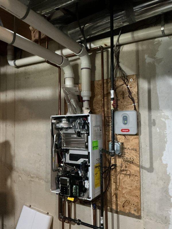 Replaced circulation pump and shut-off kit on wall-mounted heating unit under full warranty coverage. Unit accessed by removing front panel to expose heat exchanger and internal mechanical components, with new circulator and associated shut-off valving installed per manufacturer specifications.