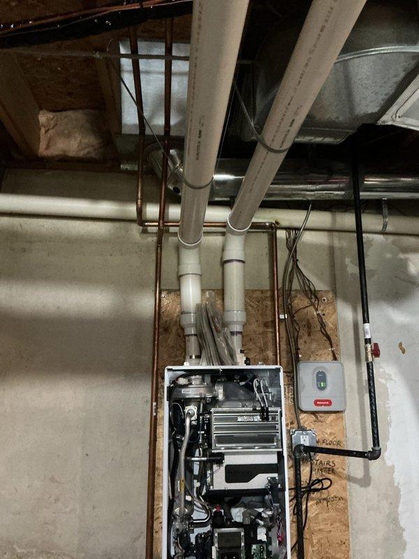 Replaced circulation pump and shut-off kit on wall-mounted heating unit under full warranty coverage. Unit accessed by removing front panel to expose heat exchanger and internal mechanical components, with new circulator and associated shut-off valving installed per manufacturer specifications.