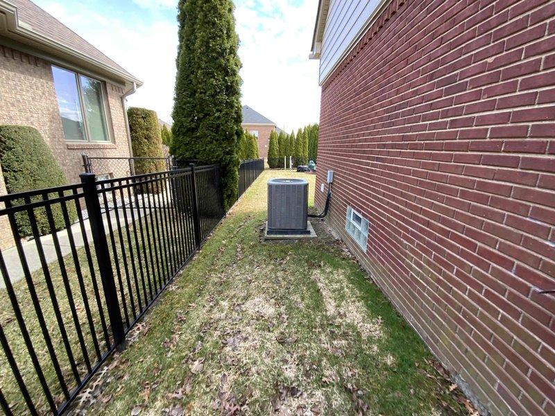 Completed comprehensive estimate for full HVAC system replacement at owner-occupied residence. Assessed existing 25-year-old furnace and 15-year-old air conditioning system, with exterior condensing unit located in side yard on concrete pad against brick structure. Documented current equipment configuration, electrical disconnect, and site conditions to provide replacement options for both heating and cooling equipment.