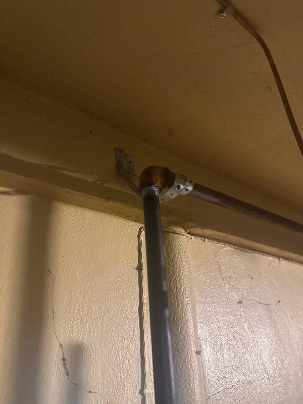 Returned to address code violations identified during inspection of recently installed 110,000 BTU furnace and 4-ton air conditioning system. Corrected gas piping support to comply with MSS SP-58 standards, reinstalled condensing furnace vent per manufacturer specifications, properly connected NM cable ground to junction box fed with Type AC cable, and sealed unused junction box openings with approved methods.