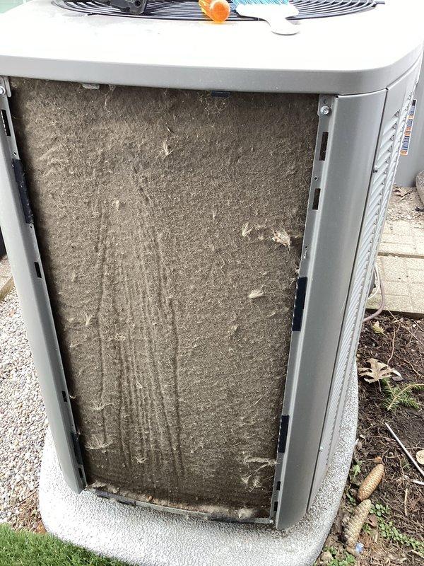 # HVAC Maintenance - ACM Completed

Performed routine air conditioning maintenance on residential split system outdoor condensing unit. Upon arrival, conducted visual inspection of equipment exterior and surrounding area. Opened access panel to evaluate air filter condition and discovered heavily contaminated flat panel filter with significant dust and debris accumulation throughout surface area. Filter exhibited gray-brown discoloration with uneven distribution patterns and material clumping, indicating extended service interval.

Removed and replaced soiled air filter with new filter media to restore proper airflow and system efficiency. Inspected condenser coil fins for damage, debris, and airflow obstruction. Verified fan blade assembly operation and checked for proper rotation. Examined unit mounting on concrete pad for levelness and stability. Assessed gravel and soil drainage around equipment base to ensure adequate water runoff and prevent standing water issues.

Documented equ