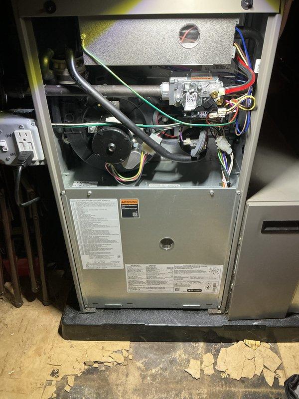 Completed annual heating maintenance and tune-up on furnace system. Performed comprehensive inspection of all internal components including blower motor assembly, heat exchanger, gas valve controls, electrical connections, and safety systems. Verified proper operation of pressure gauge, checked all wire connections and terminals for secure contact, and inspected burner assembly and ignition components. All systems tested and found operating within normal parameters. Unit photographed for service documentation showing accessible internal components and current system condition.
