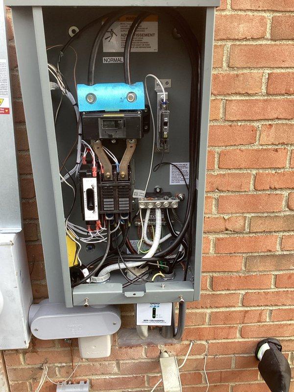 Completed installation of 26KW RCA standby generator with 200-amp automatic transfer switch. Obtained all required permits including mechanical, electrical, generator, gas piping, pressure test, and transfer switch permits. Installed exterior-mounted 200-amp transfer switch panel on brick wall with proper conduit routing, circuit breaker configuration, and wiring connections. Connected generator to existing electrical service with appropriate grounding, bonding, and safety labeling per NEC standards. Performed gas line installation and pressure testing to supply fuel to generator unit. Configured automatic transfer switch for seamless transition between normal utility power and generator backup power. All electrical connections, terminal blocks, and wiring harnesses properly secured and labeled within transfer switch enclosure. Installation completed with all components operational and compliant with local electrical codes.