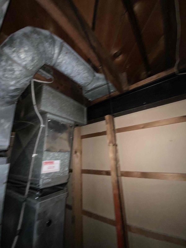 Provided comprehensive estimate for complete HVAC system replacement in basement location, including both furnace and air conditioning unit. Existing equipment is over 20 years old with non-functional air conditioning system, featuring natural gas furnace with aged galvanized metal exterior, flexible metal ductwork showing dust accumulation and discoloration, and standard residential configuration with exposed wooden structural elements. Assessed current installation layout, ductwork routing, electrical conduit connections, and equipment accessibility to develop replacement specifications for new high-efficiency heating and cooling system.