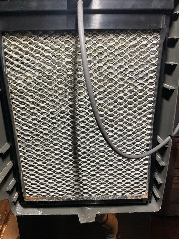 Completed comprehensive HVAC tune-up on 5+ year old basement unit, including thorough inspection of furnace, humidifier, thermostat, and hot water tank. Replaced heavily soiled air filter showing significant dust and debris accumulation with new pleated filter to restore proper airflow and system efficiency. Installed new humidifier pad and verified all system components operating within normal parameters.