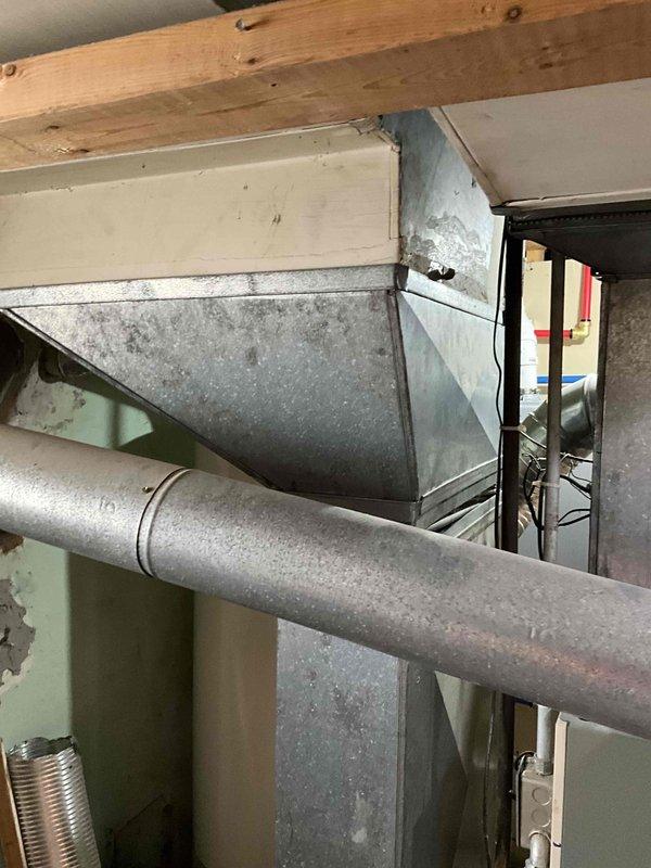 Provided estimate for complete furnace and air conditioning system replacement in basement location. Existing 40-year-old furnace currently operational but at end of service life, with no existing central air conditioning system present. Assessment included evaluation of current ductwork infrastructure, humidifier integration requirements, and spatial considerations for new equipment installation in utility room alongside existing water heater.