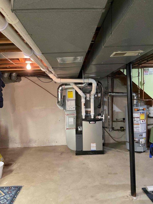 Completed full HVAC system installation including a 90,000 BTU furnace and 3-ton air conditioning unit with rear discharge configuration. Obtained mechanical and electrical permits prior to installation. Installed new furnace in basement utility area with proper PVC venting and ductwork connections. Mounted outdoor condenser unit at exterior brick wall corner with appropriate electrical disconnect box and conduit routing. Reconnected all necessary utilities and verified system operation upon completion.