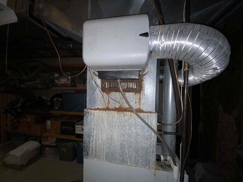 Conducted comprehensive assessment of existing HVAC system in basement utility area for equipment replacement estimate. Evaluated aging furnace unit showing significant deterioration including rust staining on cabinet panels and general wear indicative of extended service life. Inspected associated components including humidifier, flexible aluminum ductwork, copper refrigerant lines, and electrical connections. Documented current system configuration and condition through photographic evidence to support replacement recommendations and equipment specifications for complete system upgrade.