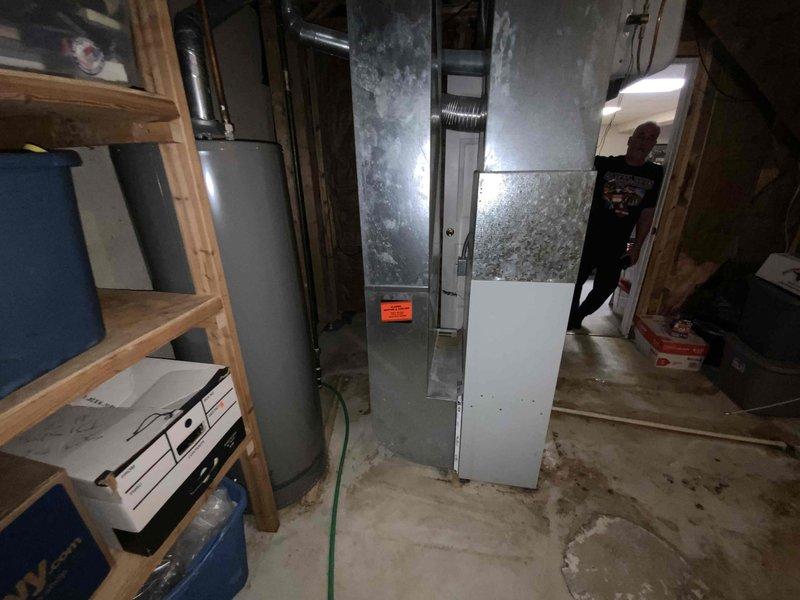 Conducted comprehensive assessment of existing HVAC system in basement utility area for equipment replacement estimate. Evaluated aging furnace unit showing significant deterioration including rust staining on cabinet panels and general wear indicative of extended service life. Inspected associated components including humidifier, flexible aluminum ductwork, copper refrigerant lines, and electrical connections. Documented current system configuration and condition through photographic evidence to support replacement recommendations and equipment specifications for complete system upgrade.