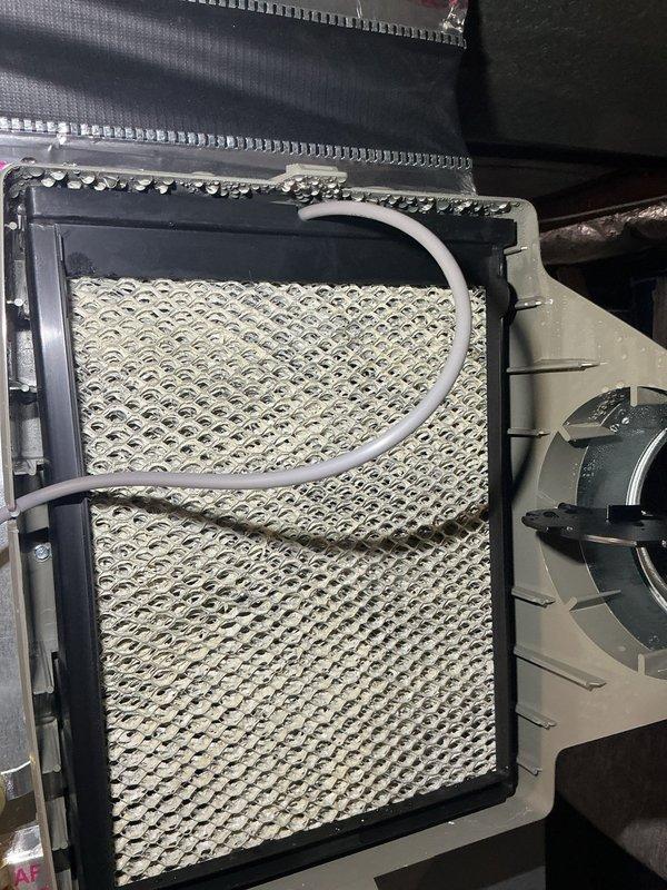 Responded to warranty service call for forced air furnace system installed less than one year ago with complaint of humidifier running continuously. Upon inspection, examined humidifier assembly and evaporator pad within the HVAC unit. Verified humidifier operation and checked humidistat settings and control wiring. Inspected honeycomb evaporator pad for mineral buildup or saturation issues that could affect proper cycling. Examined condensate drain line routing and blower assembly integration with humidifier system. Assessed airflow distribution components including supply diffuser to ensure proper system operation. System maintained heating capability throughout service call. Completed diagnostic evaluation and made necessary adjustments to resolve continuous run condition under warranty coverage.