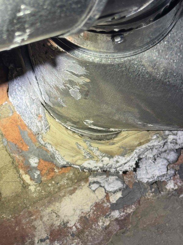 Completed comprehensive HVAC system evaluation for 20-year-old natural gas furnace and air conditioning equipment located in basement. Assessed existing blower motor assembly showing significant age-related wear, moisture damage, and corrosion on metal components and surrounding concrete base with visible efflorescence and deterioration. Documented current ductwork configuration including humidifier accessory unit mounted to main supply plenum, water heater proximity, and overall mechanical room layout to provide accurate replacement system specifications and installation requirements.