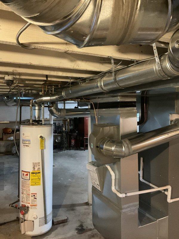 Completed full HVAC system installation including 70,000 BTU furnace with liner and 2-ton Lennox air conditioning unit with rear discharge configuration. Installed humidifier, performed duct alterations in basement, and ran new dedicated electrical circuit with disconnect. All mechanical and electrical permits obtained and work performed to code specifications, with outdoor condensing unit mounted on composite pad with PVC condensate drainage and indoor air handler integrated with existing ductwork infrastructure.