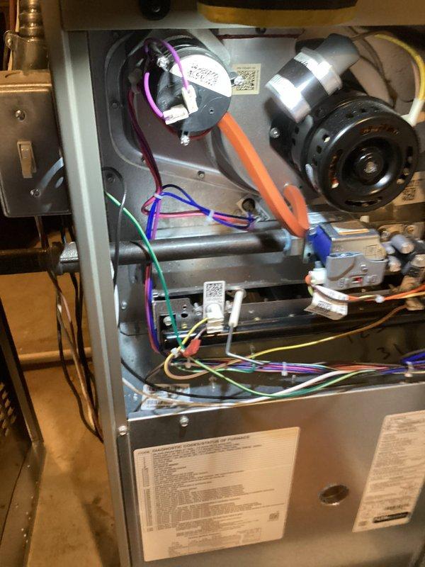 Completed annual furnace maintenance on Lennox brand heating unit installed in utility closet. Performed comprehensive tune-up inspection including removal of access panel to examine internal components, wiring connections, blower motor assembly, and control modules. Verified proper operation of pressure switch, examined all electrical connections including purple, blue, orange, green, and yellow wiring harnesses, and confirmed secure mounting of circuit boards and control systems. Inspected blower motor condition, orange condensate tubing, and copper refrigerant lines running along exterior of unit. All components found to be in good operational condition with no visible signs of wear, damage, or safety concerns. Unit operating within normal parameters with proper ventilation through perforated front panel. Reinstalled access panel and confirmed system functionality upon completion of maintenance protocol.