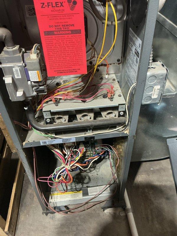 Responded to no-heat call on basement-located furnace less than 10 years old with thermostat set to 77°F but unit failing to initiate heating cycle. Performed diagnostic assessment of furnace components including temperature sensor testing, control board inspection, and thermostat signal verification. Examined internal wiring connections, terminal blocks, and electrical components for proper continuity and secure connections. Assessed venting system integrity and verified proper installation of exhaust components. Documented system conditions through diagnostic photography showing temperature probe readings and internal component configuration to identify cause of heating failure and restore proper furnace operation.