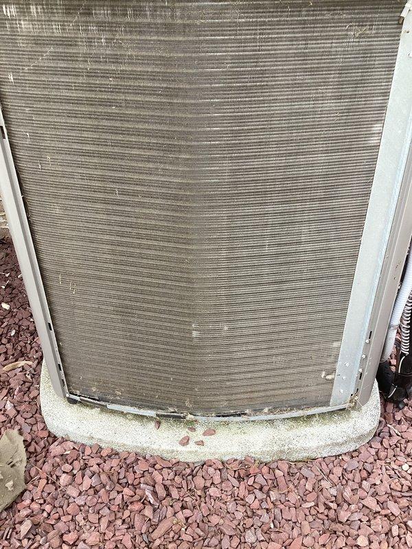 Performed annual cooling maintenance on outdoor condensing unit. Upon inspection, found heavy accumulation of dirt, dust, and debris on condenser coils and internal components. Removed front access panel and thoroughly cleaned condenser coil fins to restore proper airflow and heat transfer efficiency. Removed compacted grime and debris from interior surfaces. Verified unit operational status and cleared landscaping rock from concrete pad. System restored to optimal operating condition for cooling season.