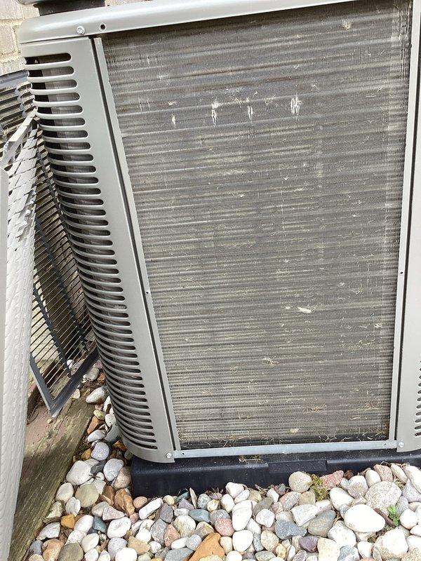 Completed second appointment of annual cooling maintenance service at two residential properties. Performed comprehensive inspection of outdoor condensing units, including visual assessment of cabinet condition, coil cleanliness, and electrical connections. Documented equipment condition with photos showing condenser with debris accumulation on mesh screening and open service panel revealing refrigerant lines, wiring, and internal components in operational status.