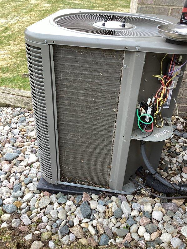 Completed second appointment of annual cooling maintenance service at two residential properties. Performed comprehensive inspection of outdoor condensing units, including visual assessment of cabinet condition, coil cleanliness, and electrical connections. Documented equipment condition with photos showing condenser with debris accumulation on mesh screening and open service panel revealing refrigerant lines, wiring, and internal components in operational status.