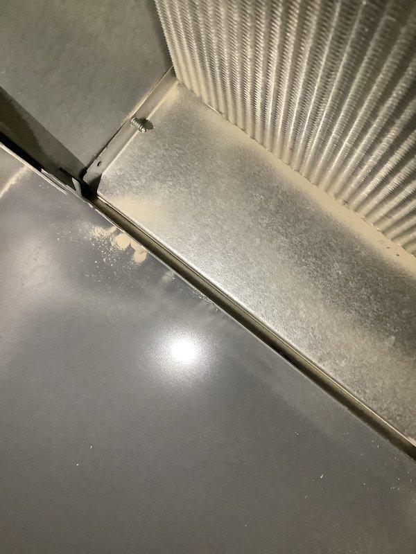 Responded to no heat call for furnace system located in basement, approximately 2015 model. Upon inspection, discovered significant moisture condensation and frost accumulation on heat exchanger surfaces and adjacent ductwork components. Examined heat exchanger fins, which showed evidence of abnormal condensation patterns indicating potential airflow restriction or combustion issues. Documented condition of corrugated metal heat exchanger sections and metallic ductwork connections. Moisture buildup on system components suggests possible secondary heat exchanger drainage blockage, restricted airflow due to dirty filter or blower issues, or condensate system malfunction requiring further diagnostic evaluation and repair to restore proper heating operation.
