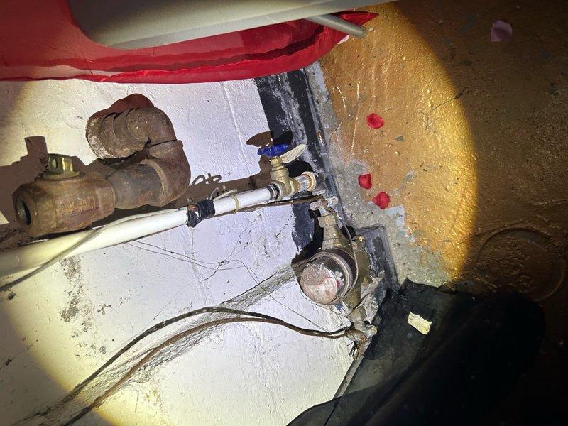 Responded to emergency water heater repair call for issue that had just developed in residential property. Upon inspection, identified problem with tanked water heater system located in basement utility area. Examined main water heater unit and associated plumbing connections, including pressure relief valve assembly, shut-off valves, and supply line connections. Noted aging galvanized components with surface oxidation and copper piping showing corrosion and mineral deposits. Evaluated blue-handled shut-off valve, pressure gauge functionality, and various brass fittings throughout the system. Addressed the immediate malfunction to restore hot water service to the residence. Tested system operation following repairs to ensure proper pressure levels and verify no leaks at connection points. Documented equipment condition and captured photos of the installation for service records.