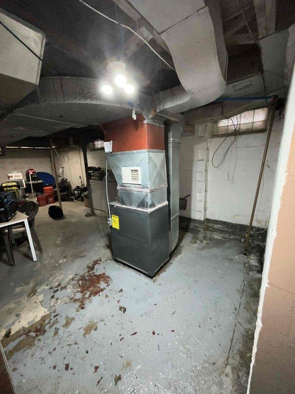 Conducted site assessment for air conditioning system installation at residential property currently without cooling equipment. Evaluated basement-located natural gas furnace and existing ductwork configuration to determine compatibility and requirements for new A/C system addition. Documented equipment dimensions and spatial measurements to prepare comprehensive replacement estimate for complete cooling system integration with existing heating infrastructure.