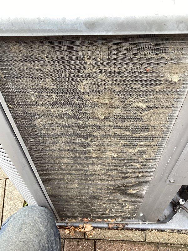 Completed annual cooling maintenance on rooftop zone unit. Inspected condenser coil and found heavy accumulation of dust, dirt, debris, and fibrous material restricting airflow through fins. Cleaned condenser coil thoroughly to restore proper heat transfer efficiency. Removed access panels, evaluated internal components, and verified unit operational status. Documented equipment condition with photographs showing before-condition of heavily soiled coil with significant particulate buildup. Unit returned to normal operating parameters following coil cleaning and system evaluation.