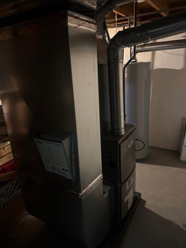 Completed full HVAC system installation including a 70,000 BTU furnace and 2.5 ton air conditioning unit with rear discharge configuration. Coordinated with electrical panel upgrade to 100 amp service performed same day to support new equipment load requirements. Installed all necessary ductwork connections, leveled equipment on proper mounting platform, and completed system reconnection. Obtained required mechanical and electrical permits prior to installation. Verified proper equipment alignment and secure mounting of both furnace and AC condenser units in basement mechanical room with all black ductwork properly connected and sealed.