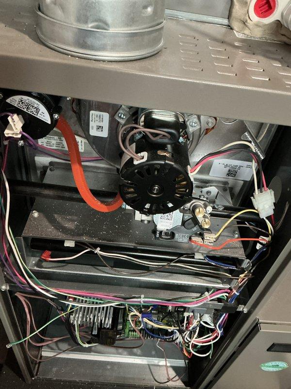 Completed annual furnace heating maintenance and tune-up on brand new heating system under membership agreement. Performed comprehensive inspection of blower motor assembly, electrical connections, and control board components. Verified all wiring harnesses, including red, white, pink, yellow, blue, green, and black wire connections were properly secured and functioning correctly. Inspected internal compartment components, motor mounting brackets, and ductwork connections. All systems tested and operating within normal parameters with no issues found.