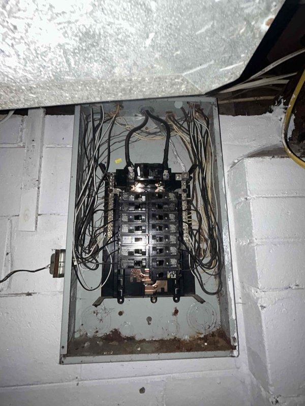 Conducted residential furnace replacement estimate for a seven-year-old heating system showing visible signs of age and deterioration. Documented existing equipment condition, including worn exterior casing and aging infrastructure within the utility space. Photographed electrical panel configuration, existing ductwork connections, and current furnace installation to assess replacement requirements and ensure proper sizing for new equipment installation.