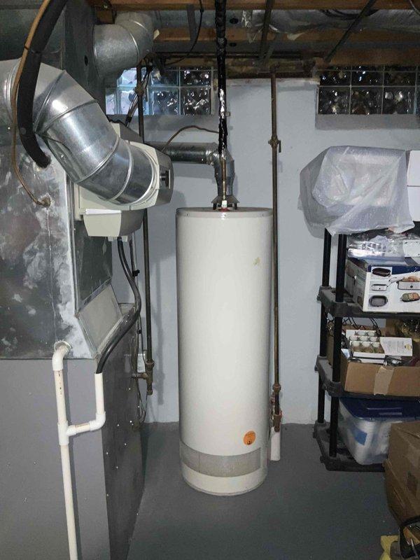 Conducted full system assessment for 2,400 square foot two-story residence with 16-year-old HVAC equipment experiencing induced draft motor failure on furnace and aging air conditioning unit. Evaluated existing basement-installed gas furnace with upflow ductwork configuration, central air conditioning system, and aging 50-gallon water heater suspended from ceiling joists. Documented current equipment specifications, electrical service capacity at main panel, mechanical room layout, and existing utility connections including gas lines, condensate drainage, and ductwork routing through exposed basement joists. Provided comprehensive replacement estimate for two-stage high-efficiency furnace, high-SEER air conditioning system with improved sound ratings, and 50-gallon residential water heater suitable for household demand.