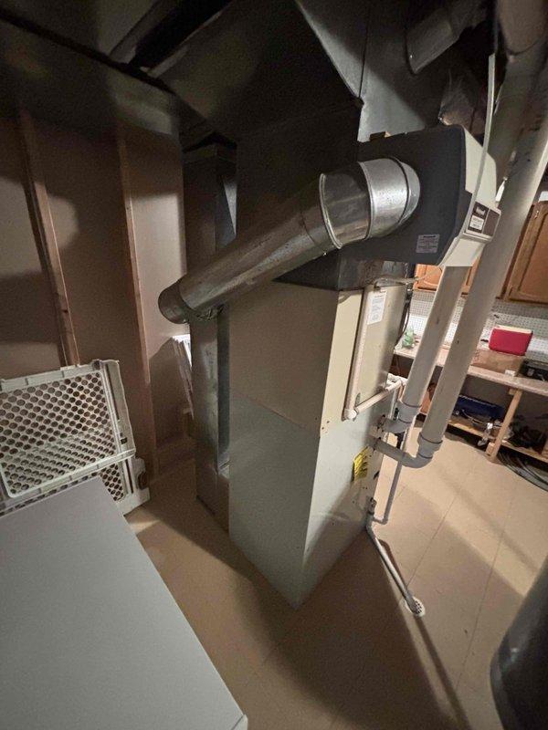 Conducted comprehensive site evaluation and prepared replacement quote for complete HVAC system replacement. Assessed existing 24-year-old Bryant furnace and air conditioning system located in basement utility area. Documented current equipment configuration including furnace unit with galvanized steel ductwork, return air grille, and complete distribution system with flexible and rigid metal ducts extending across ceiling joists. Photographed existing installation showing proper connections through ductwork and piping systems, copper refrigerant lines, and PVC condensate drainage. Evaluated mechanical room layout and clearances for replacement equipment installation. Provided detailed replacement estimate for new heating and cooling systems to replace aging units that have reached end of expected service life.