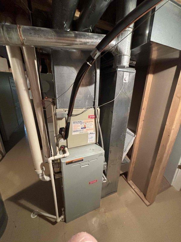 Conducted comprehensive site evaluation and prepared replacement quote for complete HVAC system replacement. Assessed existing 24-year-old Bryant furnace and air conditioning system located in basement utility area. Documented current equipment configuration including furnace unit with galvanized steel ductwork, return air grille, and complete distribution system with flexible and rigid metal ducts extending across ceiling joists. Photographed existing installation showing proper connections through ductwork and piping systems, copper refrigerant lines, and PVC condensate drainage. Evaluated mechanical room layout and clearances for replacement equipment installation. Provided detailed replacement estimate for new heating and cooling systems to replace aging units that have reached end of expected service life.