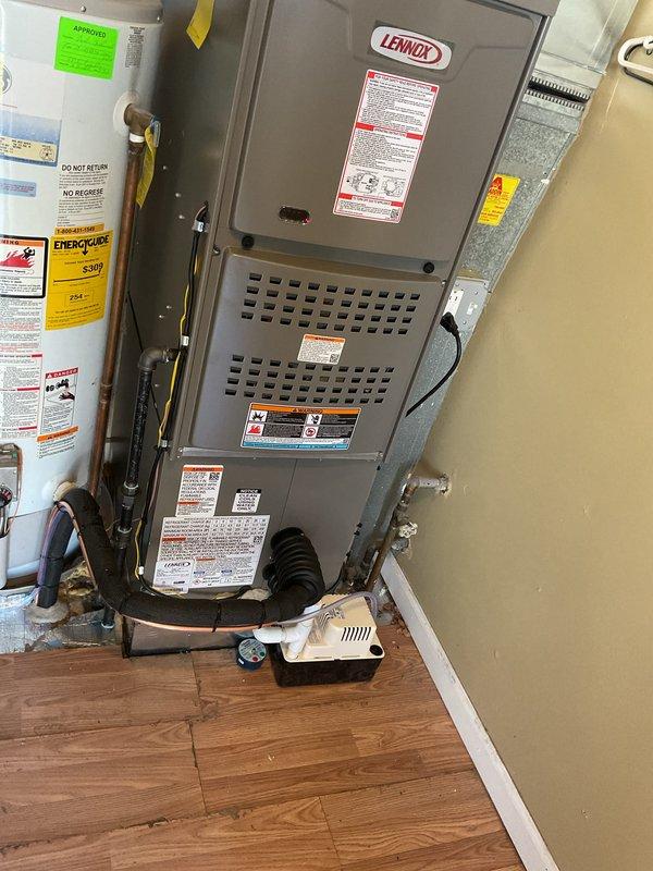 Completed full HVAC system installation including a Lennox 70,000 BTU furnace and 1.5 ton air conditioning unit with rear discharge configuration. Installed new dedicated electrical circuit to support the system, positioned furnace in utility closet with proper venting and ductwork connections, and integrated condensate pump with drainage tubing for moisture management. All mechanical and electrical permits were obtained prior to installation, and system was installed alongside existing water heater in residential mechanical room with all required safety labels, specifications, and manufacturer documentation properly affixed to equipment.
