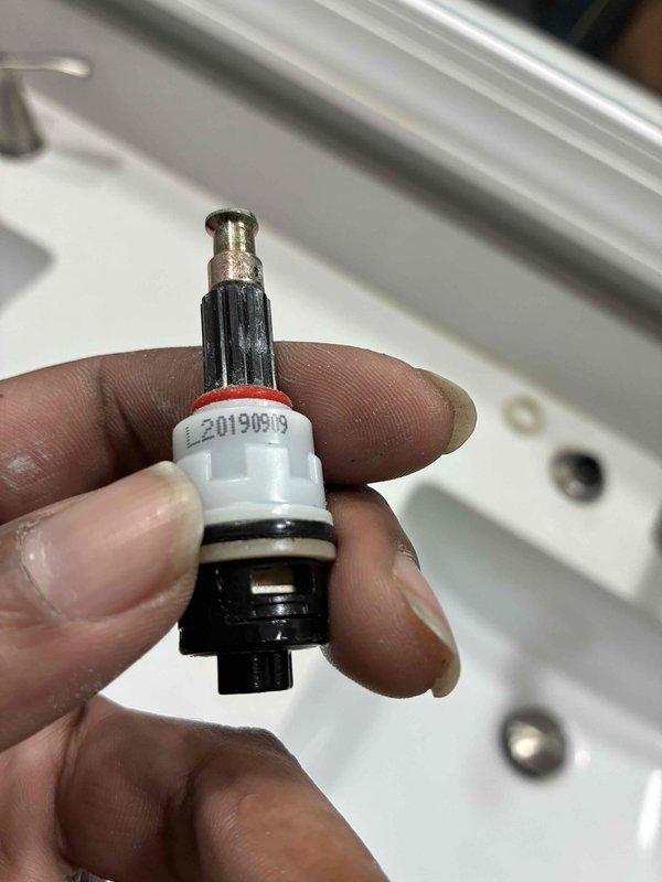 Responded to service call for multiple faucet issues including loud operation, leaking, and broken fixture. Diagnosed faulty valve cartridge (part #L20190819) as primary cause of operational problems. Removed defective cartridge from bathroom sink faucet assembly and installed replacement part to restore proper water flow and temperature control. Addressed mineral deposit buildup and corrosion visible at base of center spout mounting plate. Tested all three components of widespread faucet configuration to ensure proper operation and verified elimination of noise and leak issues.