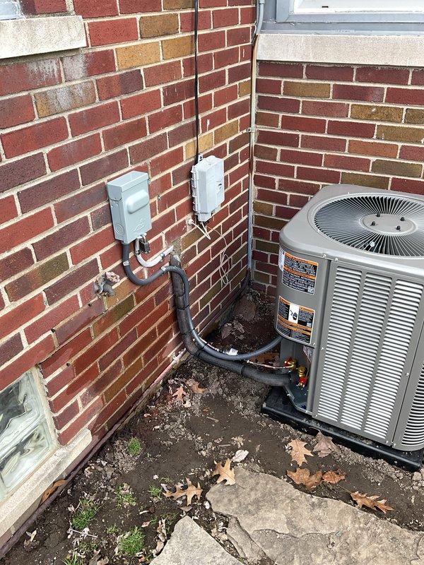 Completed full HVAC system installation including a 70,000 BTU furnace and 2-ton air conditioning unit. Furnace installed in basement utility area with proper venting and ductwork connections. AC condenser positioned on exterior left side of building in alcove area formed by brick walls. Electrical disconnect and junction boxes mounted to exterior wall with conduit run to condenser unit. All mechanical, electrical, and HVAC permits obtained prior to installation. System reconnected to existing infrastructure and tested for proper operation upon completion.