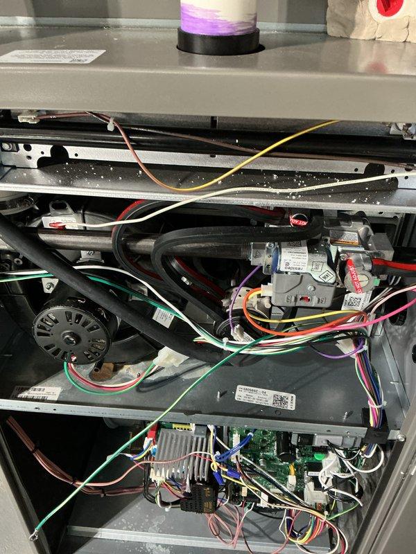 Completed comprehensive annual furnace maintenance and tune-up on residential heating system. Performed thorough inspection of all internal components including blower motor assembly, gas valve, control board, electrical connections, and wiring harnesses. Verified proper operation of all safety controls, cleaned burner assembly, checked gas pressure and combustion efficiency, inspected heat exchanger for cracks or deterioration, and tested limit switches and flame sensor. All electrical connections were examined and secured, capacitor tested within normal parameters, and blower wheel inspected for debris. System operational testing confirmed furnace is functioning properly with no issues detected. Unit photographed for service records showing internal components and control board condition.