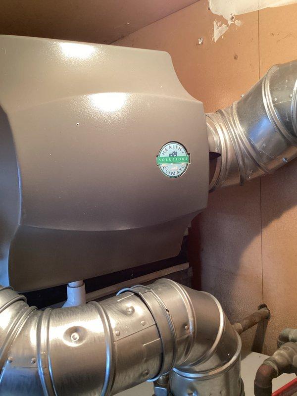 Completed full HVAC system installation including a 90,000 BTU downflow furnace (model EL297DF090XV60CK-01), 3-ton air conditioning unit with left-side configuration, whole-home humidifier, and hot water heater replacement. All equipment was installed per specifications with proper permitting for mechanical and electrical work, including reconnection of existing utilities. Installation included flashing modifications at the filter rack and plenum connection point to ensure proper airflow and system integration.