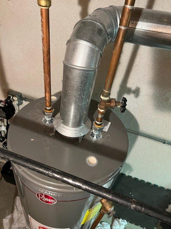 Responded to service call for water leaking around furnace with blinking red indicator light. Upon inspection, identified condensate drain issue affecting furnace operation. Performed complete tune-up maintenance on new furnace system, including inspection of heat exchanger, burner assembly, and ignition components. Cleared condensate line blockage, verified proper drainage, and tested all safety controls. Reset fault code, confirmed normal furnace operation with no error lights, and documented installation with photos of HVAC ductwork and water heater connections in attic space for service records.