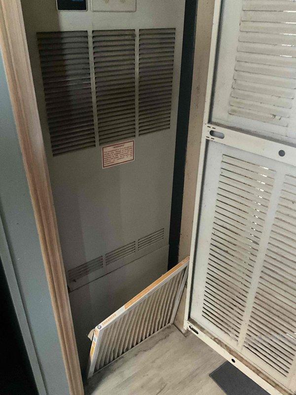 Conducted on-site evaluation for HVAC system replacement at residential property with non-operational air conditioning unit and 29-year-old Miller furnace located in hallway closet. Assessed existing natural gas furnace installation housed in enclosed utility space with louvered ventilation door access. Documented current equipment configuration including furnace positioning within wooden door frame, return air filter system, and concrete floor base. Evaluated replacement requirements for aging HVAC system to restore climate control functionality and improve energy efficiency.