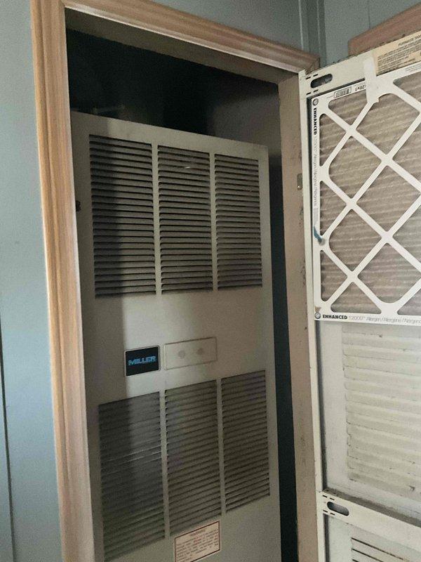 Conducted on-site evaluation for HVAC system replacement at residential property with non-operational air conditioning unit and 29-year-old Miller furnace located in hallway closet. Assessed existing natural gas furnace installation housed in enclosed utility space with louvered ventilation door access. Documented current equipment configuration including furnace positioning within wooden door frame, return air filter system, and concrete floor base. Evaluated replacement requirements for aging HVAC system to restore climate control functionality and improve energy efficiency.