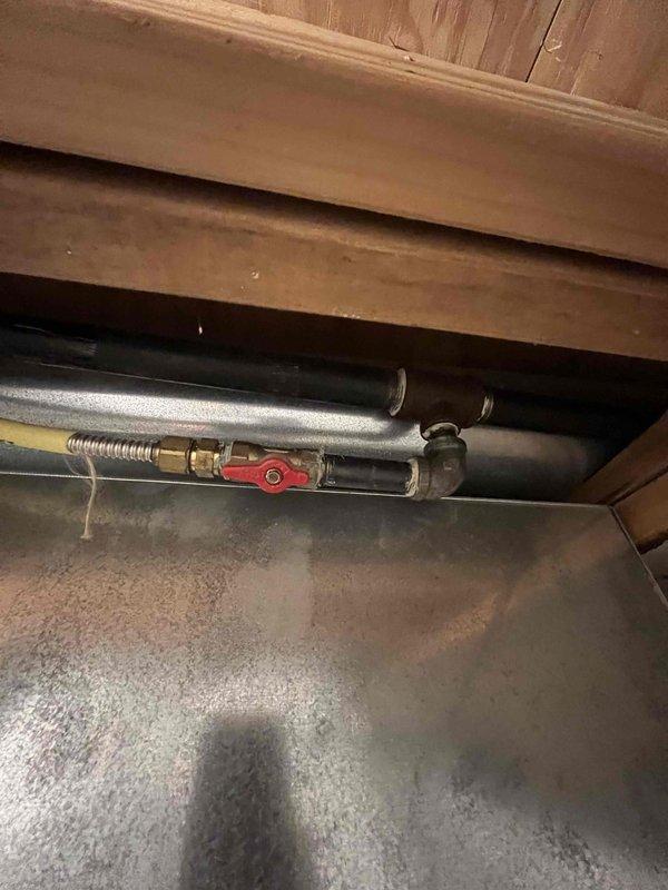 Conducted comprehensive water heater replacement estimate at residential property. Inspected existing unit and found significant corrosion and rust deterioration at top tank penetration points around copper pipe connections, indicating advanced age and potential failure risk. Evaluated existing plumbing infrastructure including red-handled ball valve shut-off, flexible braided supply lines, and copper piping configuration beneath floor joists. Assessed installation area conditions, clearances, and existing venting arrangements. Documented current equipment condition with photographic evidence showing rust staining patterns and surface scaling on tank exterior. Provided customer with detailed replacement recommendations and equipment options for new water heater installation.