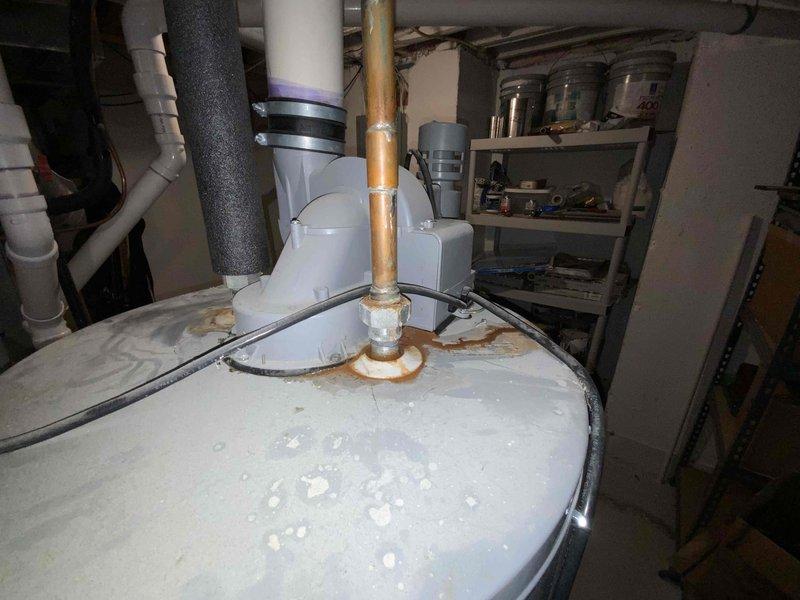 Conducted comprehensive water heater replacement estimate at residential property. Inspected existing unit and found significant corrosion and rust deterioration at top tank penetration points around copper pipe connections, indicating advanced age and potential failure risk. Evaluated existing plumbing infrastructure including red-handled ball valve shut-off, flexible braided supply lines, and copper piping configuration beneath floor joists. Assessed installation area conditions, clearances, and existing venting arrangements. Documented current equipment condition with photographic evidence showing rust staining patterns and surface scaling on tank exterior. Provided customer with detailed replacement recommendations and equipment options for new water heater installation.