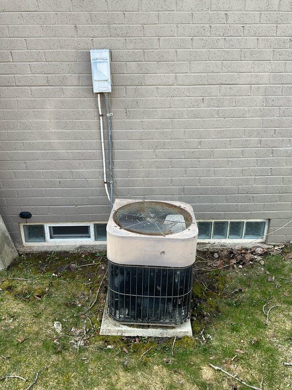 Completed HVAC system evaluation for replacement estimate on non-operational 35+ year old Lennox air conditioning condenser unit located on exterior concrete pad and basement furnace equipment. Assessed existing outdoor condenser showing significant weathering and age-related deterioration, documented electrical disconnect and refrigerant line routing through foundation, and evaluated natural gas furnace compatibility for complete system replacement recommendation.